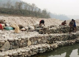 बलान नदीमा अस्थायी तटबन्ध निर्माण गर्दै सुरक्षाकर्मी